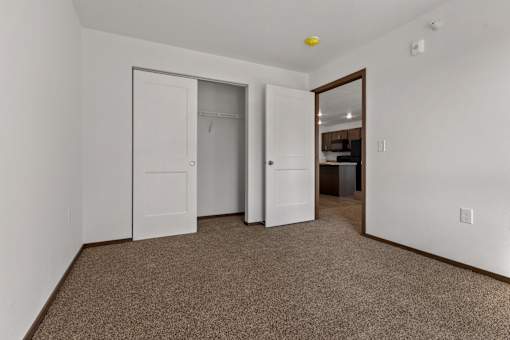 A room with a carpeted floor and a white door.
