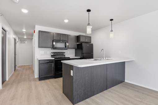A modern kitchen with a large island and stainless steel appliances.