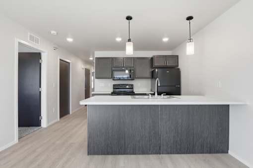 A modern kitchen with a large island and stainless steel appliances.