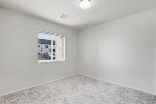 A room with a window and carpeted floor.