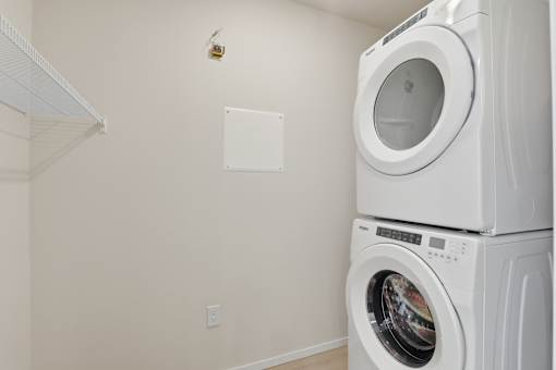 A white dryer is stacked on top of a white washing machine.