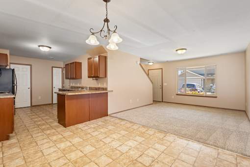 A kitchen area with a tile floor and a chandelier hanging from the ceiling.