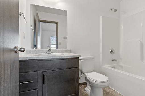 A bathroom with a toilet, sink, and bathtub.