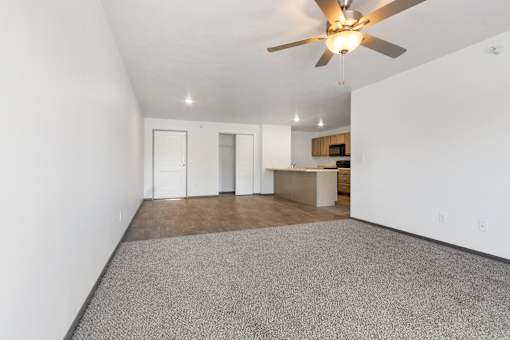A room with a ceiling fan and carpeted floor.