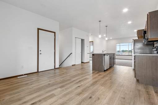 A kitchen with a wooden floor and white walls.