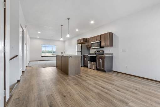 A kitchen with wooden floors and stainless steel appliances.