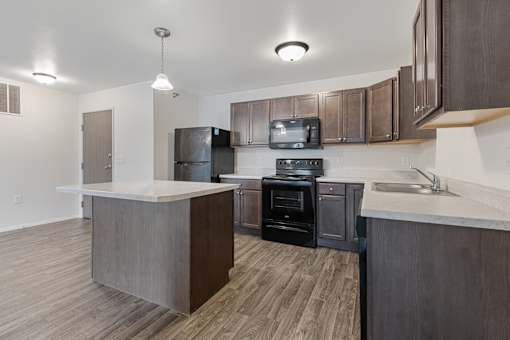 A modern kitchen with dark wood floors and a white countertop.