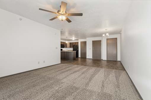 A room with a ceiling fan and carpeted floor.