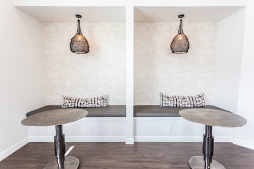 A room with a bench and a table with a lamp on top.