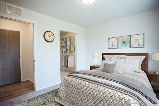A bedroom with a large bed and a clock on the wall.