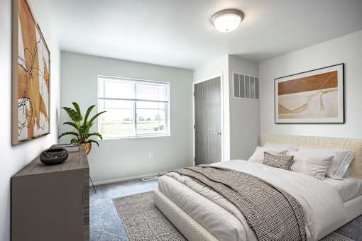 A bedroom with a large bed and a painting on the wall.
