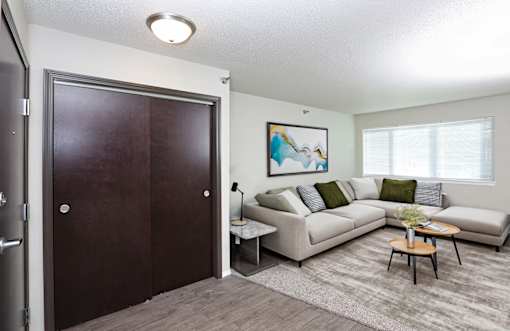 A living room with a couch, a coffee table, and a painting on the wall.