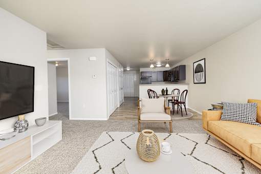 A living room with a tan couch, a television, and a rug.