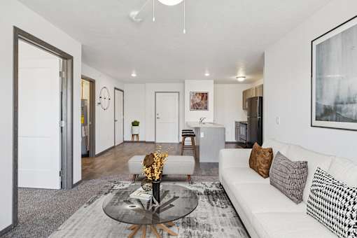 A modern living room with a white sofa and a glass coffee table.