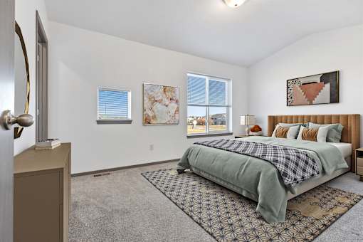 A bedroom with a bed, a dresser, and a window.