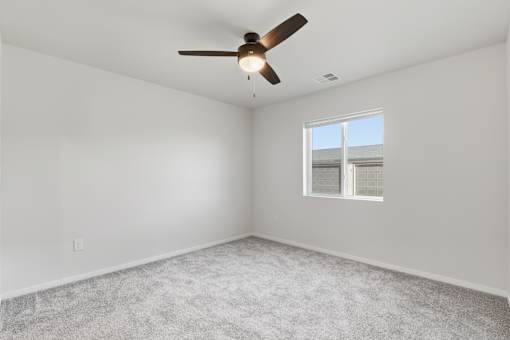 A room with a ceiling fan and a window.
