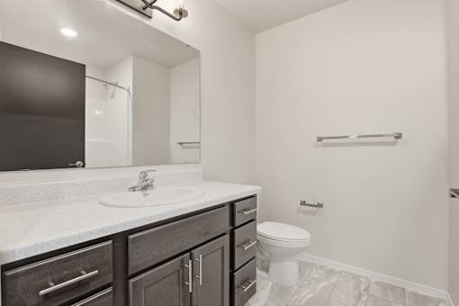A bathroom with a white sink and a toilet.