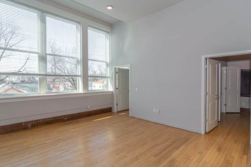 A room with a large window and wooden floors.
