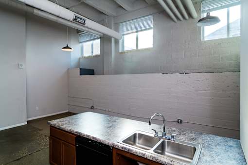 A kitchen with a granite countertop and a double sink.