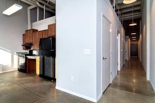A kitchen area with a black refrigerator and stove top oven.