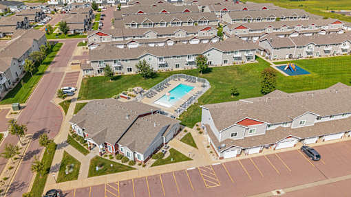 A swimming pool is surrounded by houses in a residential area.
