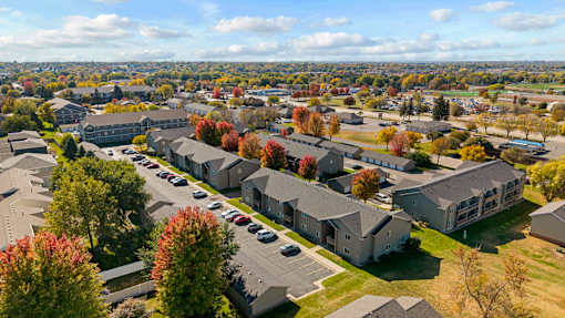 A large building complex with a parking lot in front.