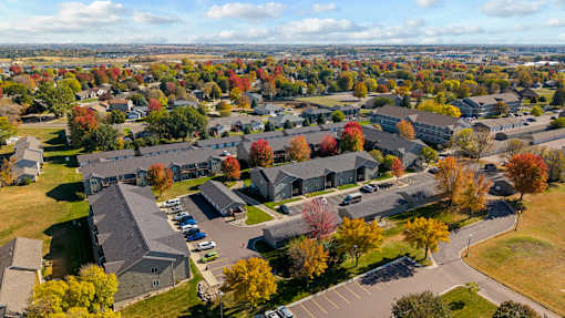 A large building complex surrounded by trees with autumn leaves.