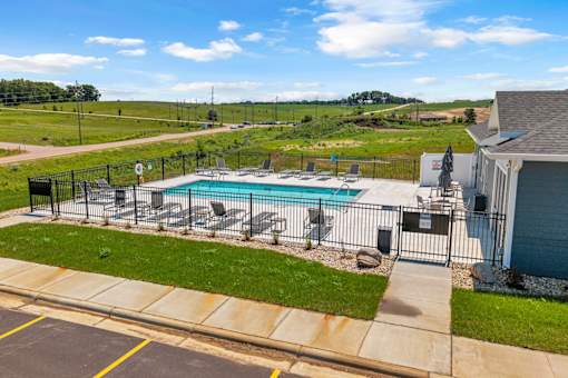 A pool surrounded by a fence and a house.