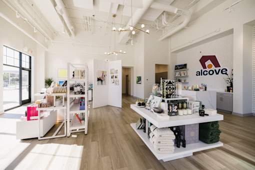 A white interior of a store with a sign that says Alcove.