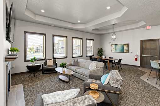 A living room with grey and white furniture and a fireplace.