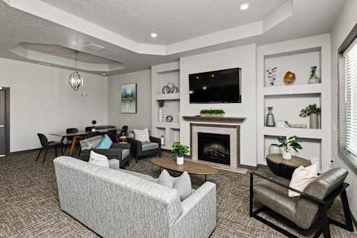 A living room with a grey couch, a fireplace, and a television.