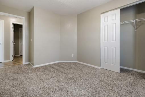 A room with a carpeted floor and a white door.