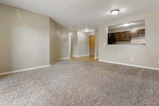 A spacious room with a carpeted floor and a mirror on the wall.