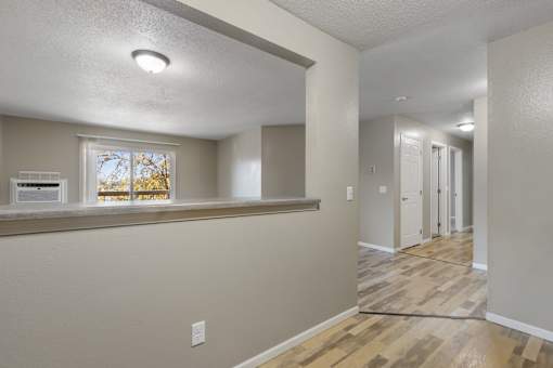 A room with a window and a wooden floor.