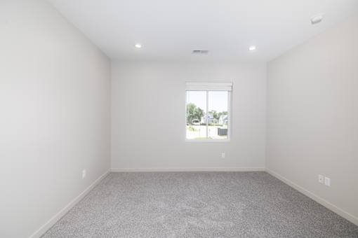 A room with a window and carpeted floor.