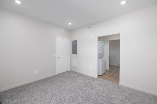 A room with a grey carpet and white walls.