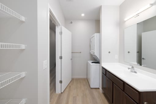 A white bathroom with a white sink and a white cabinet.