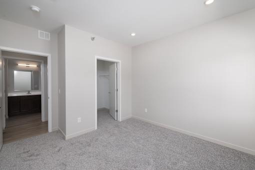 A large empty room with a carpeted floor and white walls.