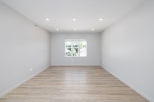 A room with wooden flooring and white walls.