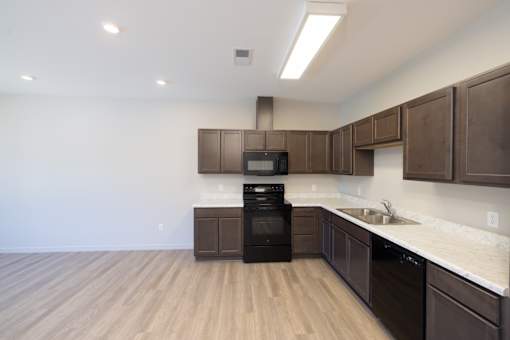 A kitchen with brown cabinets and a black oven.