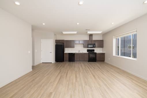 A spacious kitchen with wooden floors and modern appliances.