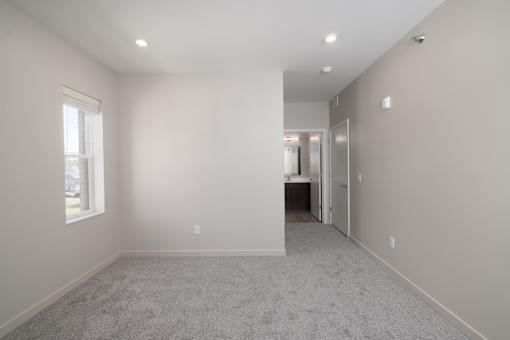 A spacious room with a carpeted floor and a window.