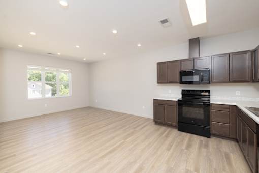 A kitchen with wooden floors and a black oven.