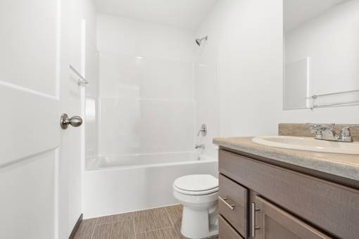A white toilet sits in a bathroom next to a sink.