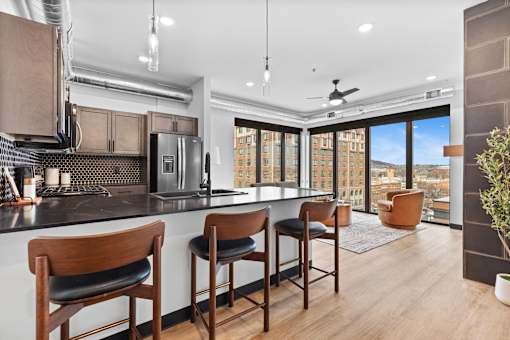 A kitchen with a bar area and a view of the city.