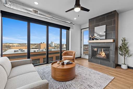 A modern living room with a fireplace and a view of the city.