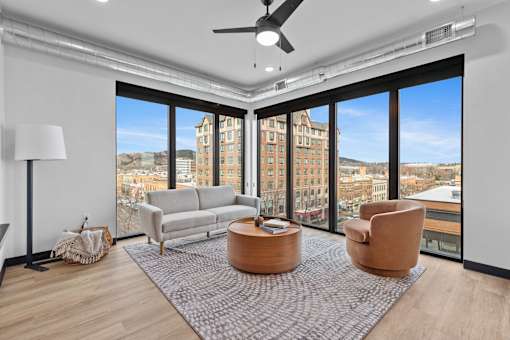 A living room with a large window overlooking a cityscape.