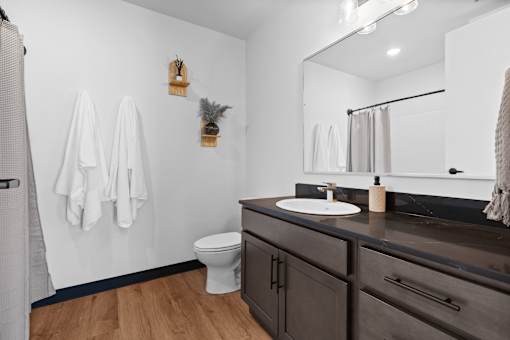 A bathroom with a toilet, sink, and towel rack.