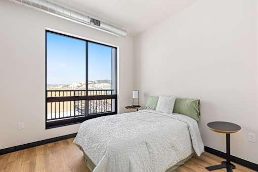 A bedroom with a large bed and a view of the mountains outside.