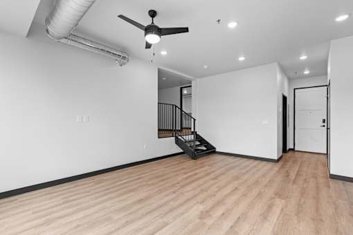 A room with a wooden floor and a ceiling fan.